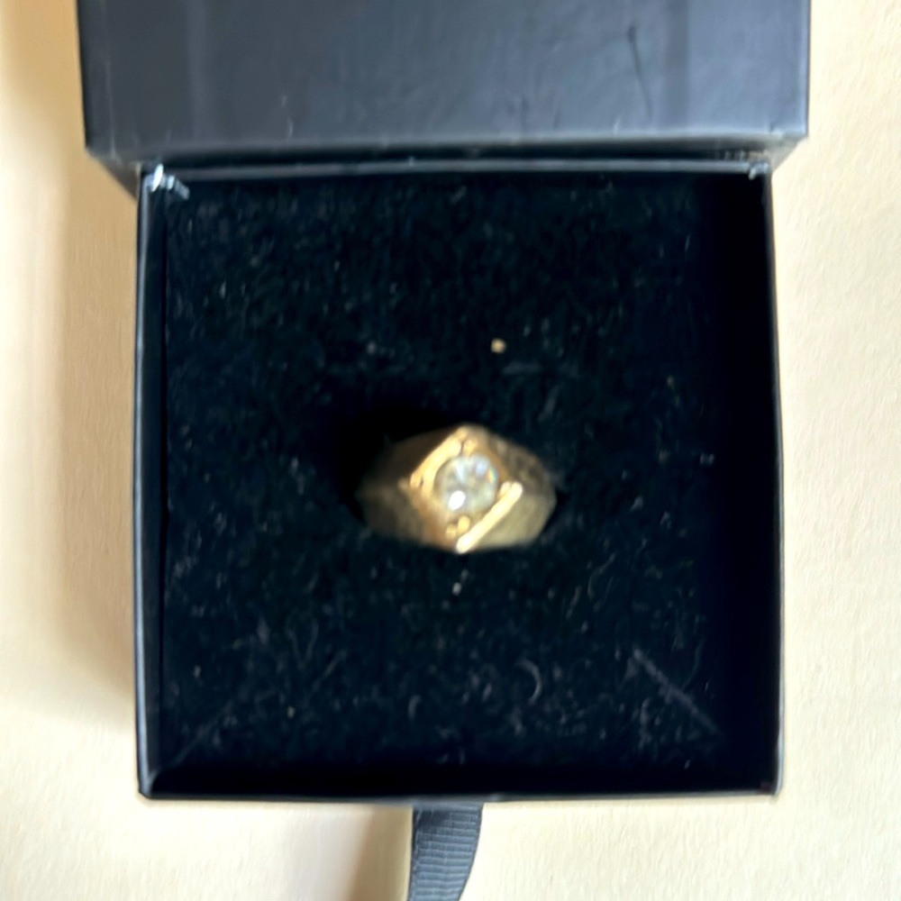 Large gold tone ring with diamond.